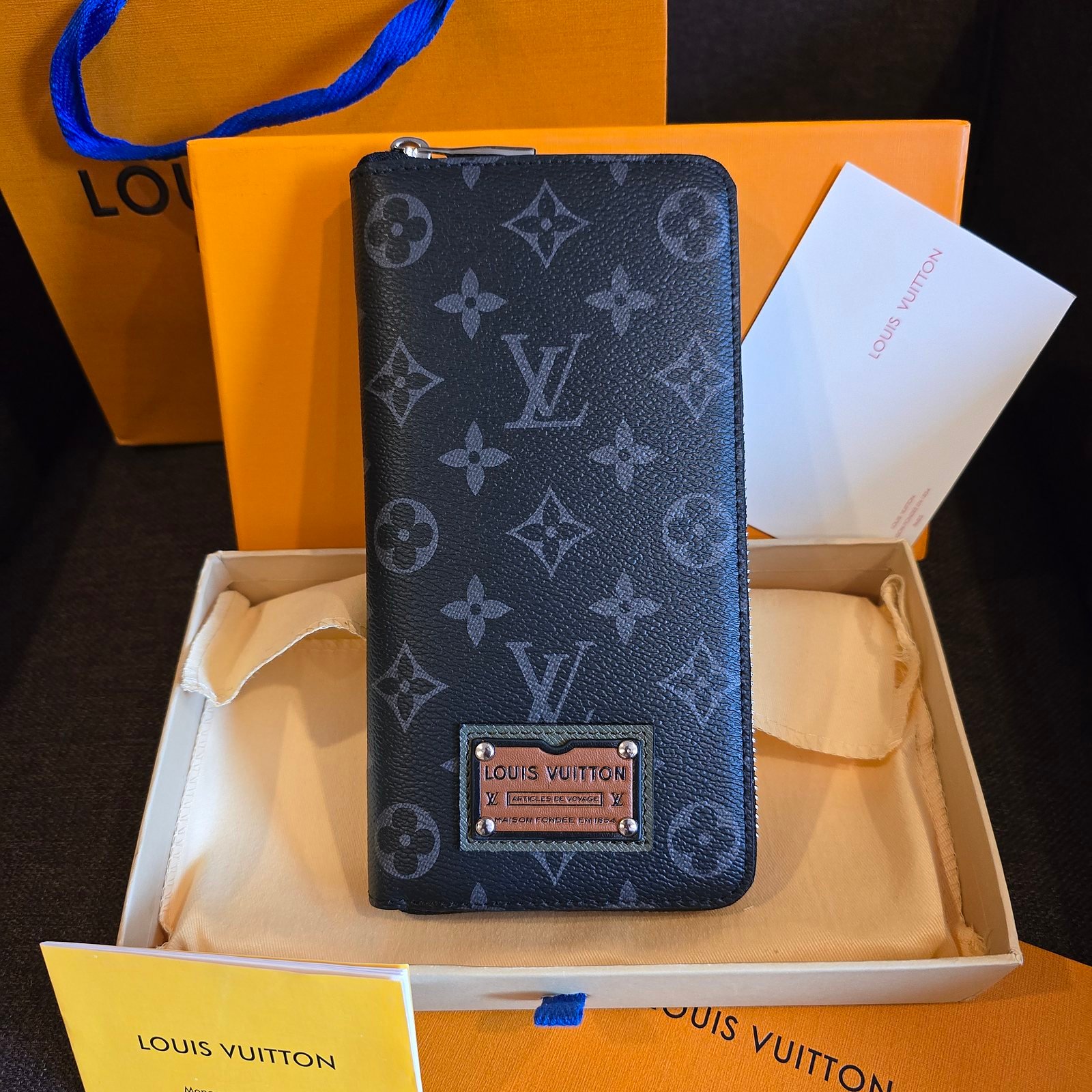 Louis Vuitton cartera con cierre lona Monogram azul con placa de piel